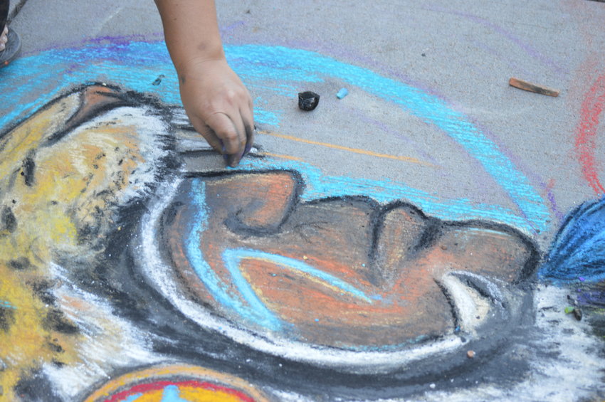 Dominique Montaño works on her art piece at the Sept. 24 Centennial Chalk Art Festival at The Streets at SouthGlenn.